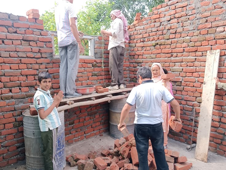 Construction volunteers repairing the roof and wall structure of a destitute home